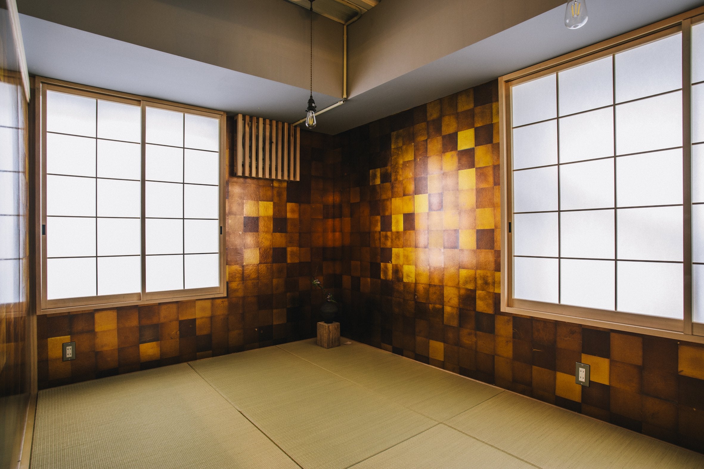 Tatami room with walls of amber and gold fumigated silver leaf squares and two shoji windows